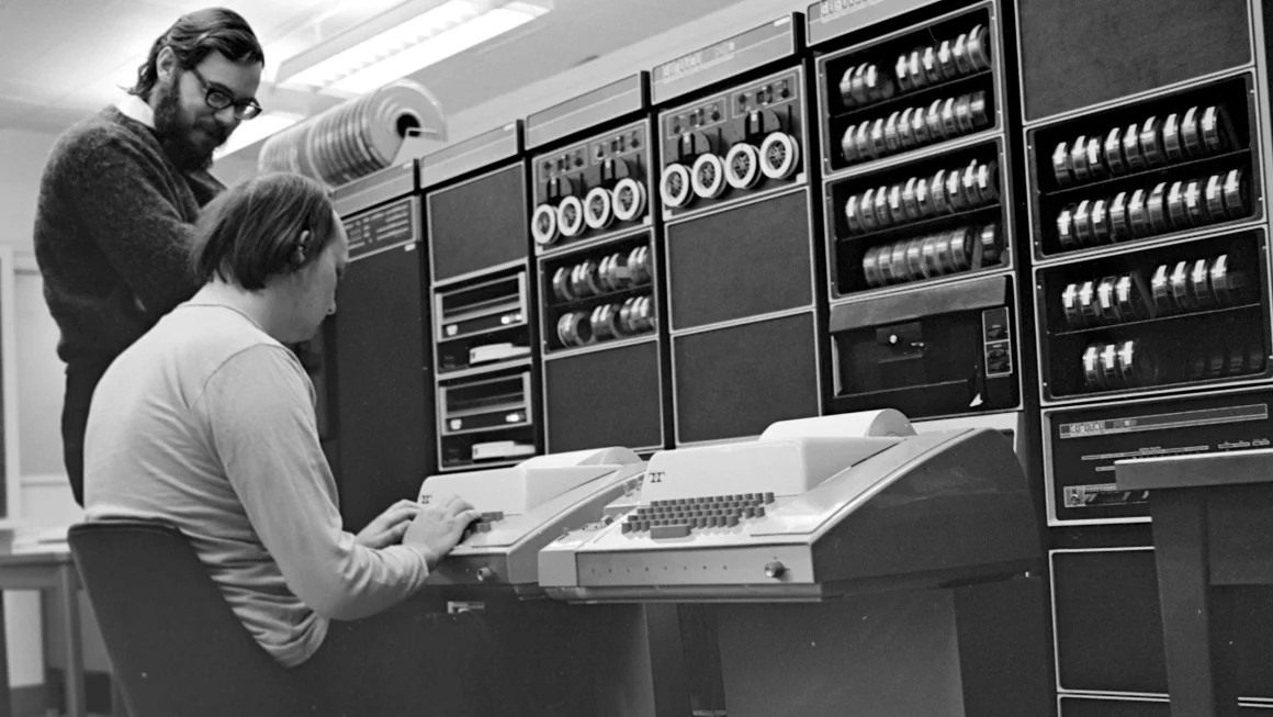 Thompson a Ritchie pracujú v Bell Labs s počítačom PDP-11